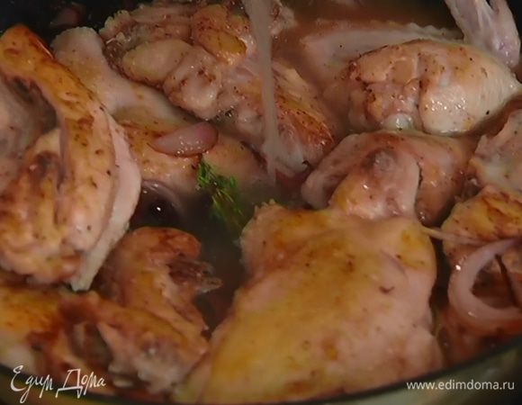 Когда лук станет мягким, вернуть в сковороду куски цыпленка, перемешать, влить уксус и горячий бульон, накрыть крышкой и готовить 40 минут.