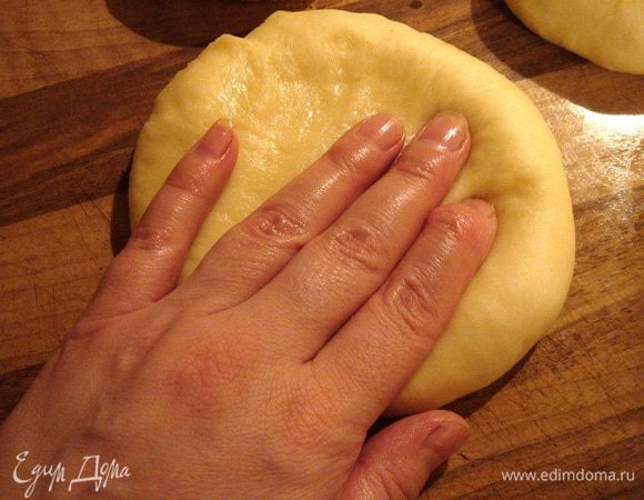 Тесто разделить на 6 (большие шаньги) или 10 частей. Скатать кусочки в шары и размять их руками в лепёшки. Переложить лепёшки на противень.