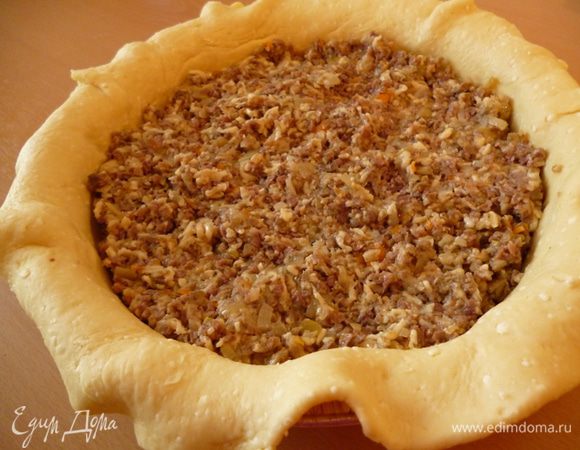 Подготовить форму для выпечки.Смазать дно маргарином и посыпать манкой или мукой.Делим тесто на две немного неравные части.Большую часть раскатать на посыпанном мукой столе в круг,он должен быть с учетом высоты бортиков формы и еще небольшой запас.С помощью скалки перенести тесто в форму.Затем выкладываем начинку.