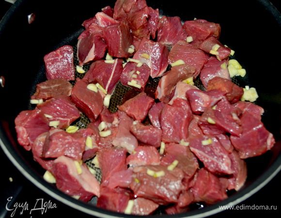 Разогреем олив.масло на сковороде с толстым дном. Выложим говядину и чеснок, жарим до коричневого цвета. Посолим и поперчим.