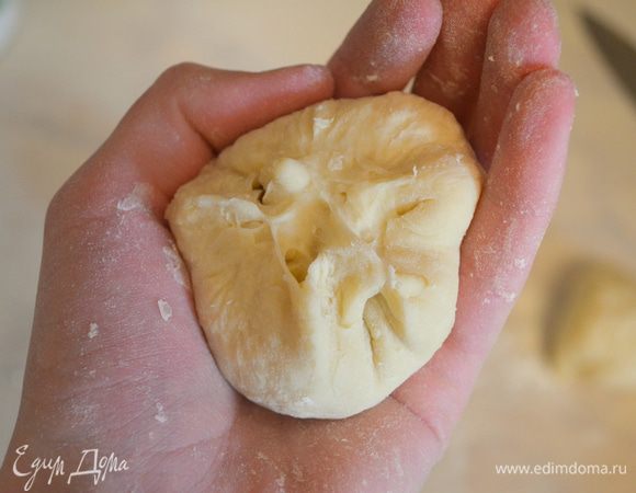 Тесто разрезаем на 8 кусочков и из каждого лепим колобок. Я беру кусочек, делаю лепешку, края лепешки собираю к центру, защипываю их и скатываю быстро в шарик. 