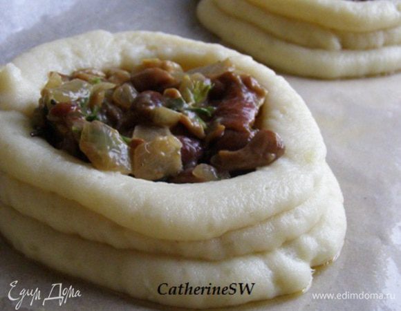 Углубления заполнить грибным фаршем. Ватрушки сбрызнуть растопленным сливочным маслом.