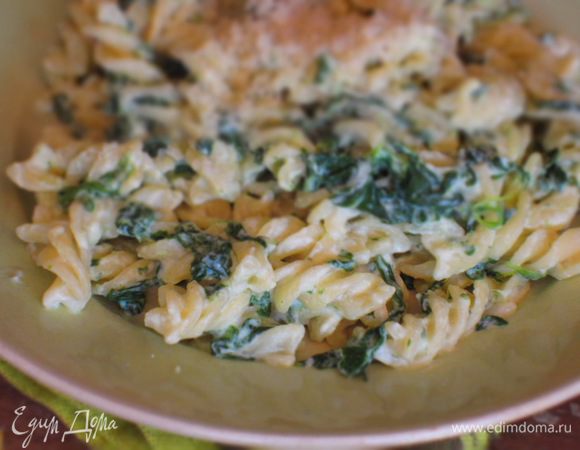 Рикотту разбавить 3-4 ст.л. воды от варки пасты (довести до кремообразного состояния) , добавить к шпинату,  перемешать. Выложить пасту  в сковороду и перемешать, затем готовить еще 2-3 минуты, чтобы объединить все ароматы.Посыпать тертым пармезаном и сразу подать к столу.Приятного аппетита:)