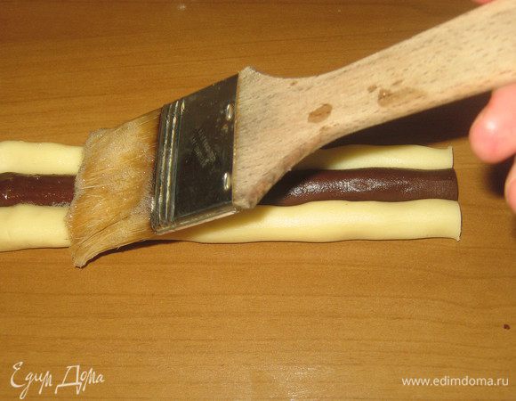 Укладывать по 3 жгутика в ряд, чередуя белые с черными.Сделать 3 слоя.Каждый слой смазать белком