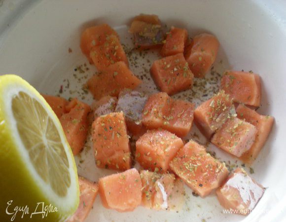 Лосось нужно нарезать небольшими кусочками. Посыпать его орегано, смесью свежемолотого перца, сбрызнуть лимоном. И оставить в миске.
Чтобы приготовить запеканку, нам необходимо отварить рис. Я брала ¾  длиннозерного риса. Отварить нужно в подсоленой воде, не разваривая. Пусть он будет лучше недовареным слегка. Оставьте рис, чтобы он слегка остыл.
