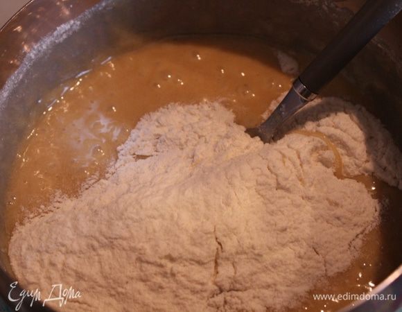 Снимите кастрюлю с бани, небольшими порциями введите муку и замесите тесто. Если оно получилось чересчур тугим и плотным, добавьте 1–2 ложки молока.