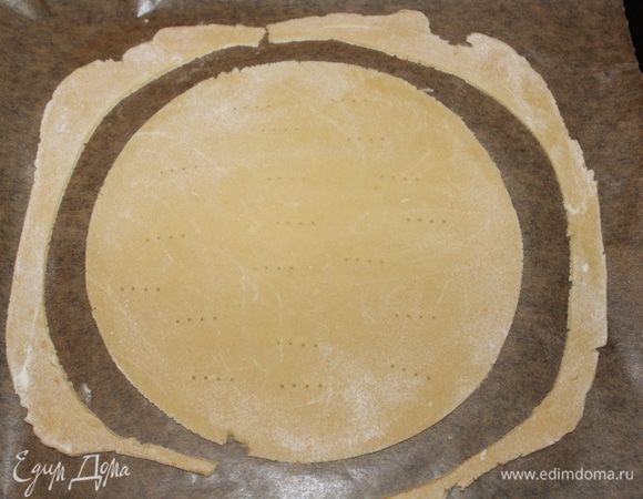 Выложите корж на противень на лист пекарской бумаги, сделайте проколы вилкой, чтобы при выпекании не образовались пузыри. Обрезки выпекайте вместе с коржом.