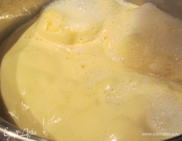 Когда молоко со сливками и с ванильным сахаром начнет закипать, добавьте все сразу взбитые желтки в молоко. Желтки поднимутся на поверхность молока.Не мешайте, дайте смеси дойти до состояния, когда молоко начнет кипеть, т.е. молоко начнет как бы выходить между стенками кастрюли и яйцами, а в центре образуются небольшие вулканчики. В этот момент венчиком размешайте желтки с молоком до образования однородной массы, буквально даже меньше минуты.