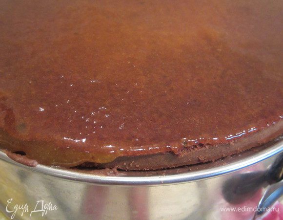 Верхний корж поливаем апельсиновым джемом, выравниваем и ставим в холодильник до его застывания.