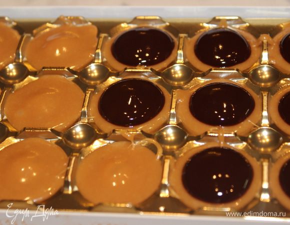 Растопить шоколад на водяной бане с добавлением 1 ст.л. сливок. Добавить сливочное масло (0,5 ст.л.), размешать. Полученную массу чайной ложкой выложить на каждую конфетку по центру