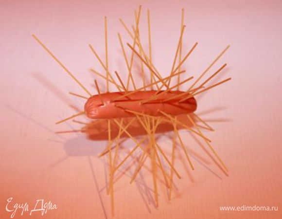 Распаковываем сосиски, чуть укорачиваем макароны. Начинаем протыкать сосиску макаронами.