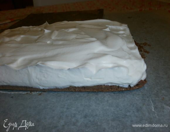 Готовый бисквит выложить на блюдо, бумагой вверх. Снять бумагу. Дать остыть окончательно бисквиту. Выложить слой крема, приблизительно высотой 1 см. Накрыть вторым слоем бисквита. Слегка придавить и поставить в морозилку на 30 минут, затем переместить в холодильник на 3 часа. 
