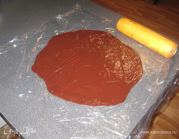 На столе расстелить широкую пищевую пленку. Выложить мастику на нее. Накрыть сверху второй частью и раскатать до нужного диаметра и толщины. 