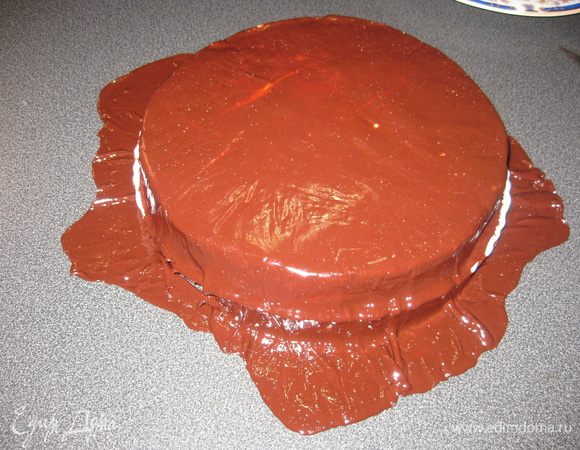 Снять верхнюю пленку. Мастику взять под нижнюю пленку и накрыть ею торт пленкой вверх. Разровнять поверхность и аккуратно снять пленку.  Обрезать лишние края по форме торта. Поставить в холодильник для охлаждения. Украсить по желанию.