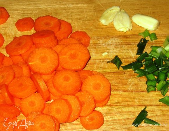 В кастрюле с кипящей водой бланшировать помидоры, снять кожицу,удалить семена и сок, нарезать кубиками. Чеснок раздавить плоской стороной ножа. Морковь нарезать кружочками.