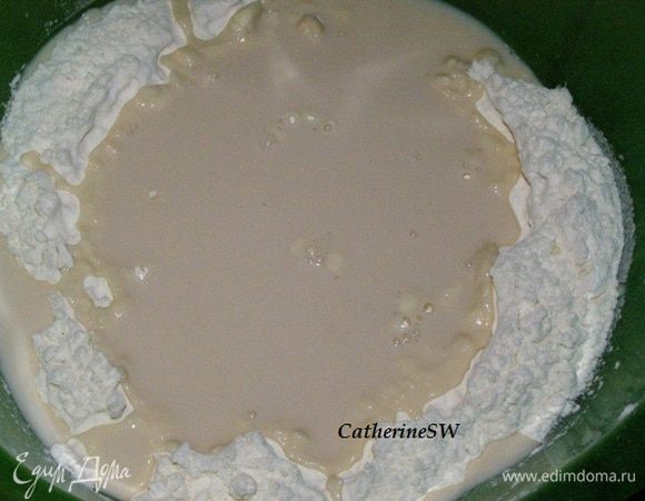 Просейте муку в миску, сделайте углубление, влейте смесь воды и молока, добавьте ⅓ часть сахара и дрожжи. Дайте дрожжам раствориться.