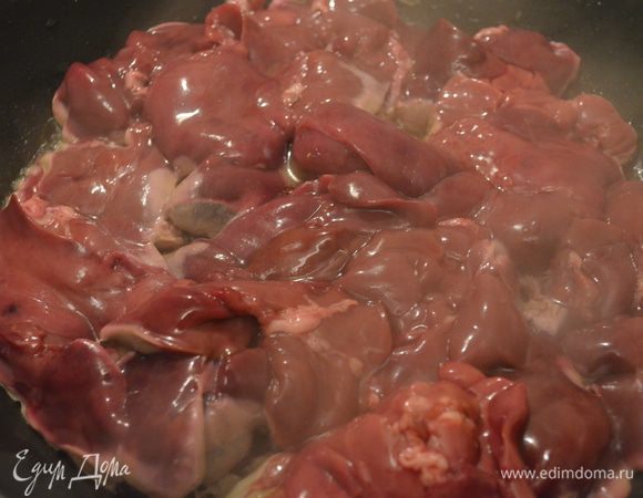 печень промыть, обсушить, обжарить на разогретой сковороде по 5 минут с каждой стороны. Затем накрыть крышкой и тушить 10 минут на среднем огне до готовности. 