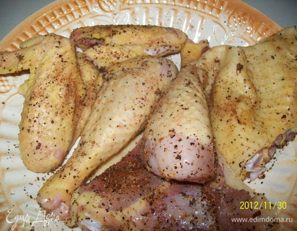 Курицу разрезать, вымыть, вытереть насухо и натереть солью, черным перцем, чесноком и красным перцем. 