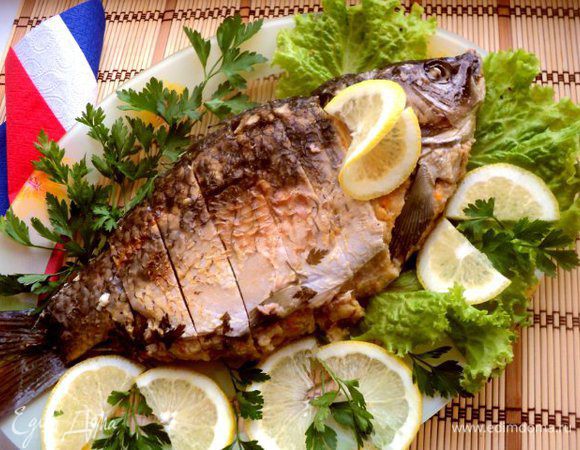 При подаче карпа порезать кусочками. украсить зеленью, лимоном, оливками.