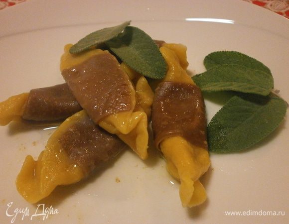 В доведённую до кипения, но не кипящую воду опускаем тортеллини и когда поднимутся, провариваем 3 минуты. Достать шумовкой и выложить в сковороду с растопленным сливочным маслом и листиками шавлии. Слегка протушить, приблизительно 3 минуты. за это время испариться лишняя жидкость и тортеллини напитаются ароматным маслом.Готовые тортеллини выложить на тарелку и полить маслом.Вот для чего нужно углубление по середине и складочка. Листья шавлии съедобные и необыкновенно вкусные. Приятного аппетита!