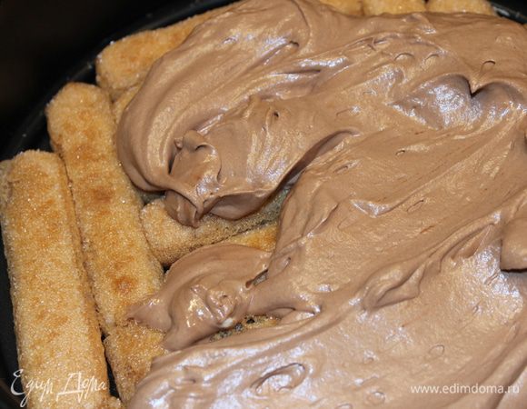 Собираем торт...Печенье, по одному обмакивая в кофе, выложить в один слой в разъемную форму. Сверху нанести шоколадный крем...все разровнять