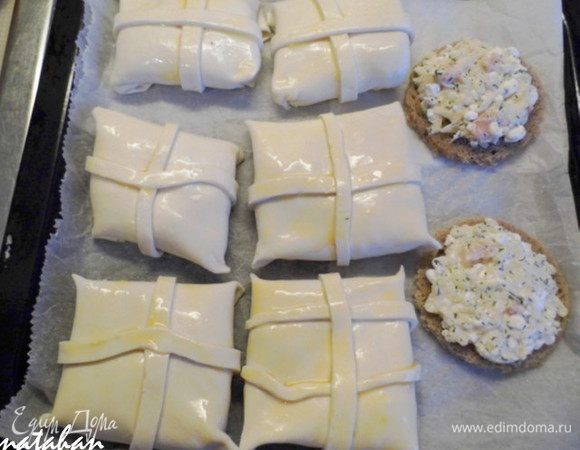 Включить духовку нагреваться на 200 градусов. Противень застелить пергаментом и выложить на него Слойки и Бутерброды. Слойки смазать взбитым яйцом.