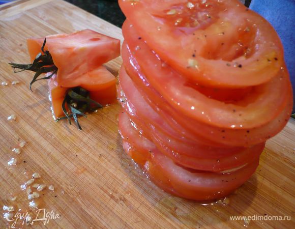 Помидоры режем на тонкие кольца, перчим и солим каждое кольцо. Укладываем стопкой и добавляем сверху 1 ст. л. масла. Даем настояться 10 минут и укладываем на салфетку, чтобы лишняя жидкость стекла.