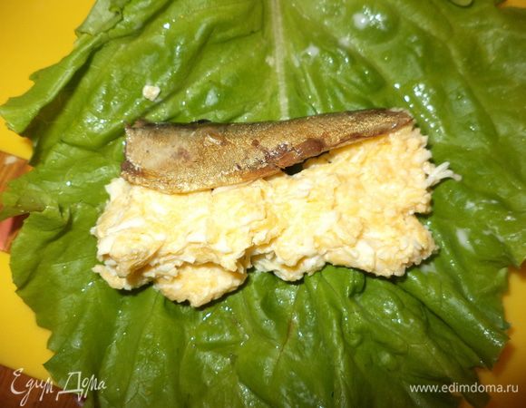 На листик салата выложить сырный салат и положить шпротинку,если они очень крупные, то делим пополам и конечно обрываем хвостики,заворачиваем