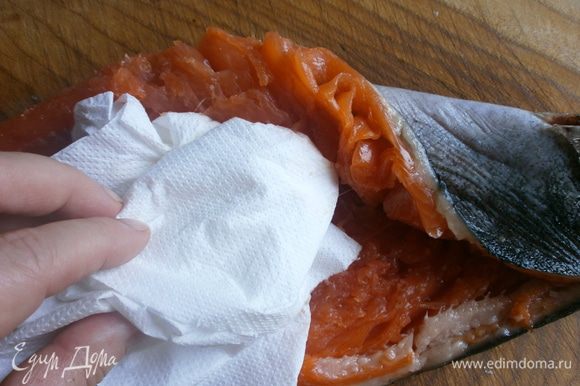 С помощью бумажного полотенца удалить кость. Удалить оставшиеся рёберные кости. Промыть и высушить рыбу изнутри.Слегка натереть солью.