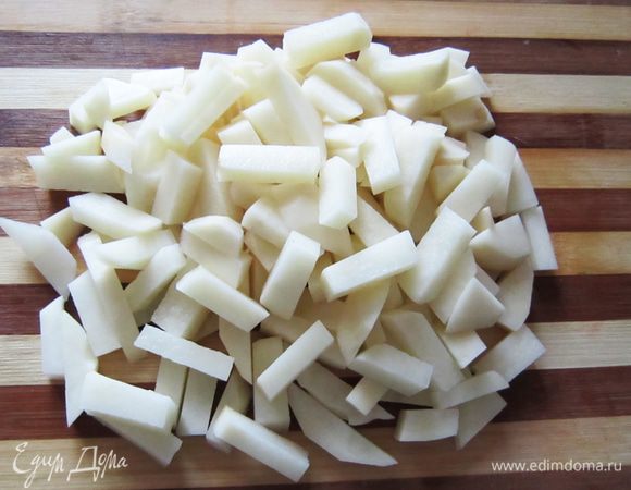 Почистите и нарежьте на брусочки картофель.