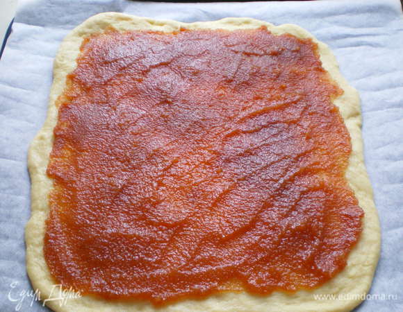 Выложите одну лепешку на противень, застеленный бумагой для выпечки и намажьте повидлом (или используйте яблоки, варенье, творог, что душа пожелает).