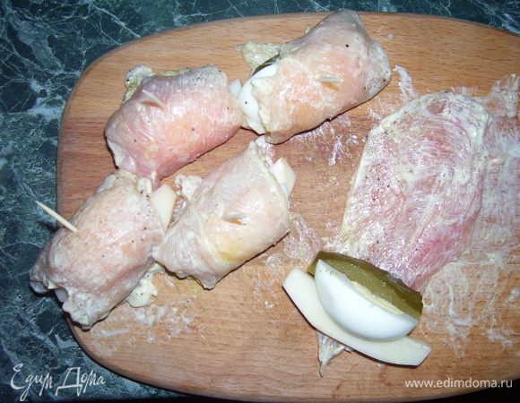 На пластины куриной грудки выложить картофель, огурец, яйцо, свернуть рулетик и закрепить зубочисткой.