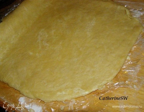 Тесто раскатаем между двумя слоями пленки. Один слой пленки снимем, Тесто с пленкой намотаем на скалку (пленка внутри)