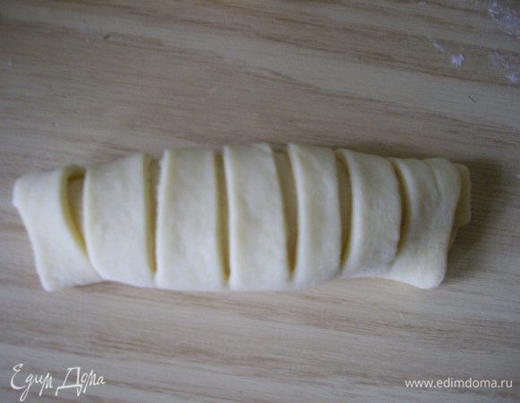 Вторую половину надрезаем, но не до конца.
Закручиваем и закрепляем, тоже белком. 