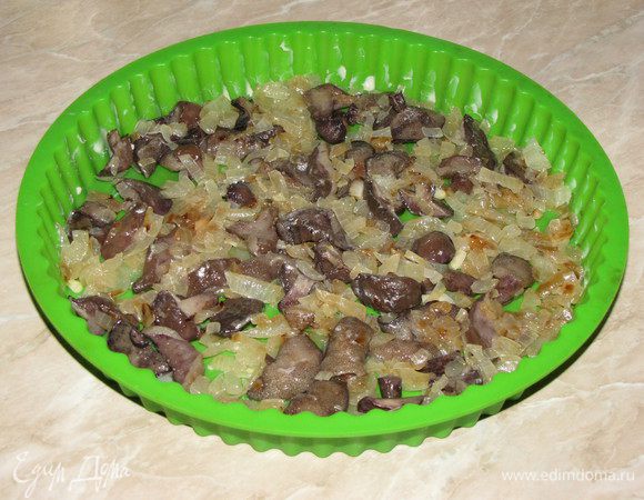 Силиконовую форму немного смазать маслом. Выложить обжаренные грибочки с луком.