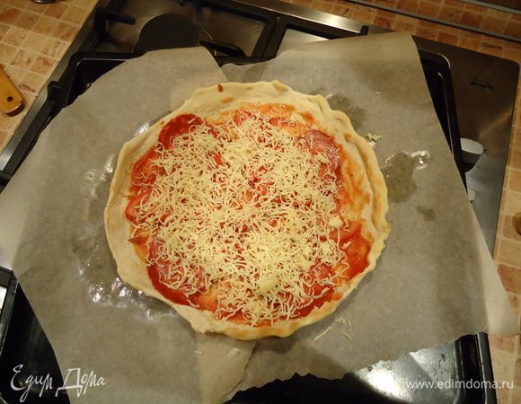 Дальше укладываем начинку: соус, колбаса, ломтики помидора, сыр. И запекаем до готовности примерно 12-15 мин.
Готовую пиццу приправить орегано и тимьяном.
