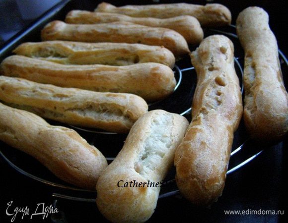 В донышке эклеров сделаем три прокола. С помощью кондитерского мешка через сделанные проколы начиним эклеры кремом. 