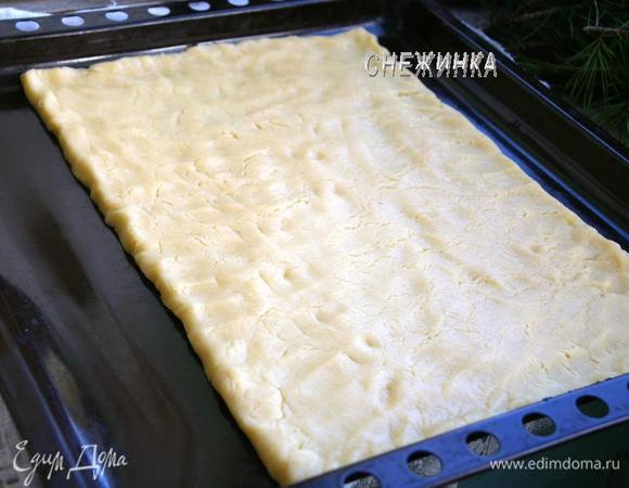 Подготавливаем противень, разогреваем плиту до 180°C. Затем раскатываем пласт прямо на противне, высотой чуть больше 1 см, я увлеклась, у меня получилось чуток меньше, но можно сделать повыше, тогда торт будет немного выше и менее прямоугольный. Не бойтесь неровных краев, мы их потом обрезаем, подравниваем. Выпекаем около 20–25 минут.