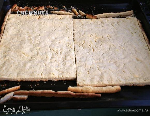 Испеченный песочный пласт достаем из духовки и сразу, пока горячий, подравниваем. Обрезаем с каждой стороны лишнее, вымеряем центр (я воспользовалась линейкой) и разрезаем на два коржа.