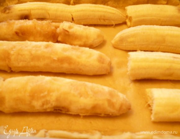 Достаем тесто из холодильника,отделяем от него 1/3 часть и кладем в морозилку.Остальное тесто раскатываем на пергаменте в корж по размеру формы с учетом высоты бортика.Тесто слегка липковатое,поэтому при раскатывании подпылить его мукой.Переносим тесто вместе с пергаментом в форму,подравниваем бортики.Затем выкладываем бананы на небольшом расстоянии друг от друга.