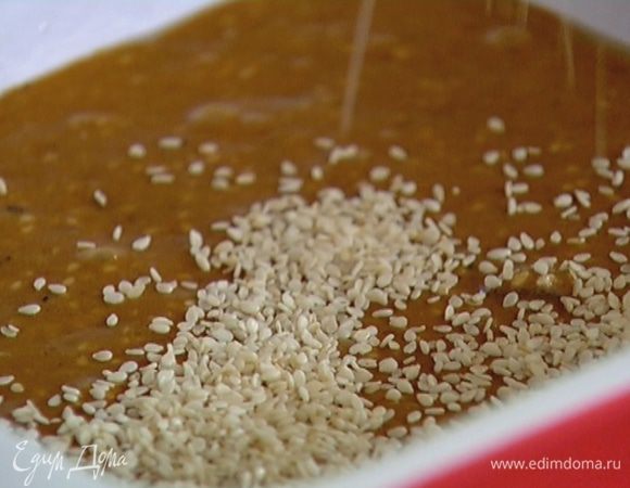 Квадратную форму для выпечки смазать растительным маслом, выложить тесто, посыпать оставшимся кунжутом и отправить в разогретую духовку на 20 минут.