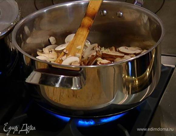 В кастрюлю к грибам добавить чеснок, часть листьев тимьяна, перемешать и продолжать обжаривать на медленном огне, не накрывая крышкой.