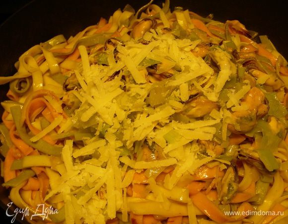 Когда паста готова, добавляем сливочное масло, мидии, пармезан (немного можно оставить для посыпки). При необходимости все немного прогреть.
