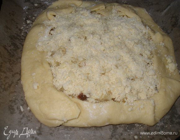 Тесто раскатать толщиной в 0.5 см, выложить начинку отступив от края 1.5 см. и загнуть края. Затем начинку засыпать крошкой. Разогреть духовку до 180-200 С и поставить выпекать минут на 20-25, до подрумянивания.