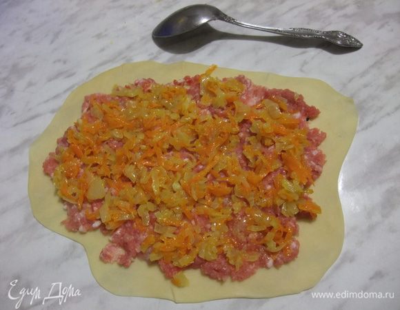 Тонко раскатайте тесто, выложите мясной фарш, на него — овощную зажарку.