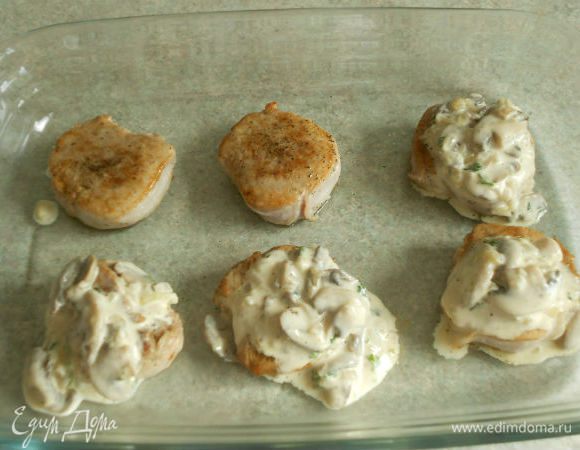 Медальоны выложить в противень, застеленный пекарской бумагой или в большое жаропрочное блюдо. На каждый положить по столовой ложке грибного соуса.