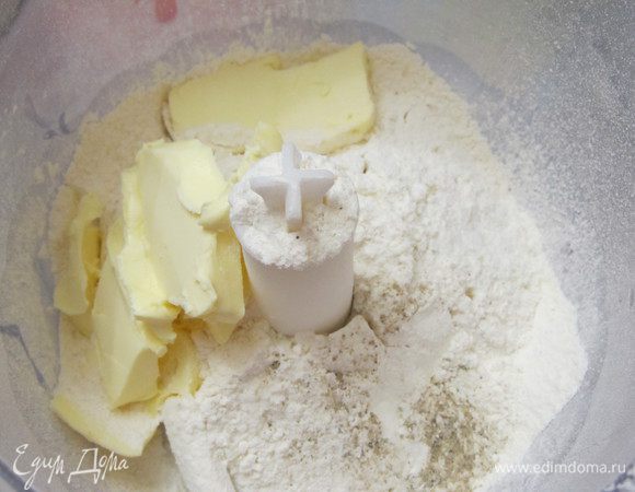 В чаше кухонного комбайна смешать просеянную муку, соль, перец. Добавить масло. Перемешать.