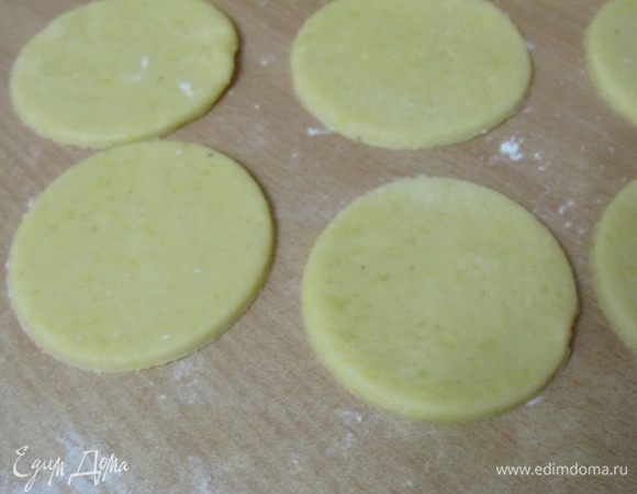 Духовку разогреть до 170 С. Противень застелить пергаментом. Рабочую поверхность присыпать мукой, раскатать тесто толщиной примерно в 0,4 - 0,3 см. Вырезать стаканом или круглой формочкой для вырезания круги. Остатки теста собрать и раскатать повторно, вырезать так же круги.