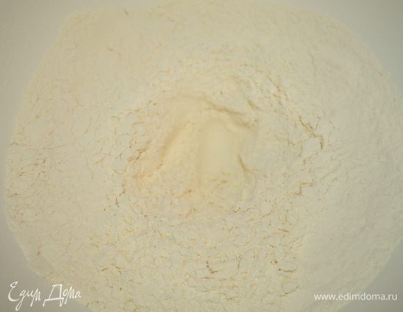 В большую миску просеять муку с солью, пряностями и содой. В центре сделать лунку