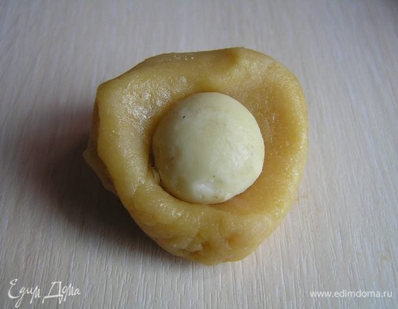 Из марципановой массы отрывать небольшие кусочки, в цендр каждого положить орех,